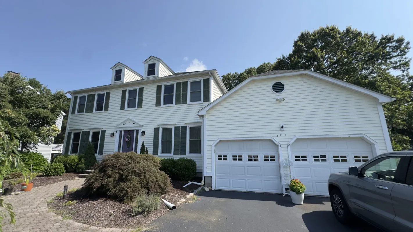 White siding house with a two-car garage and gray roof